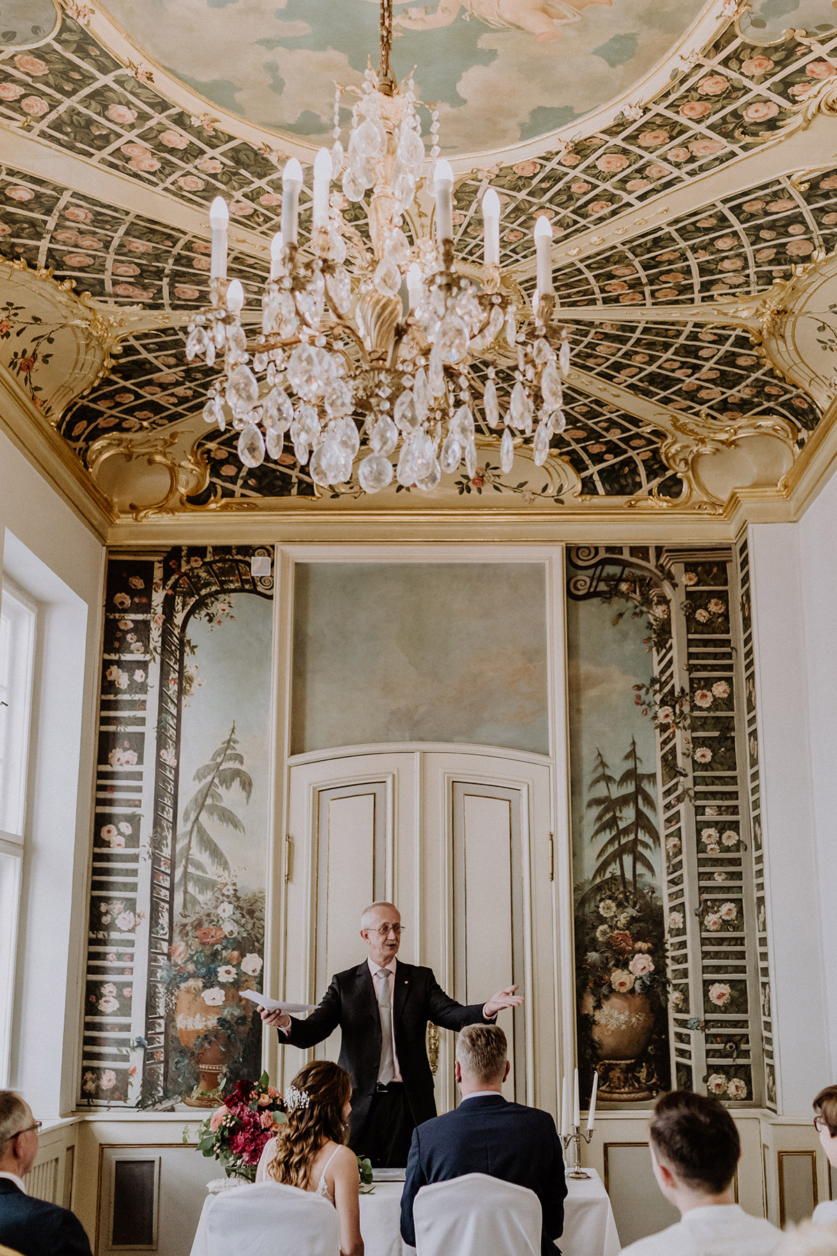 Standesbeamter hält die Traurede für das Brautpaar im prachtvollen Rosenzimmer – Hochzeitsfotograf Berlin Mitte