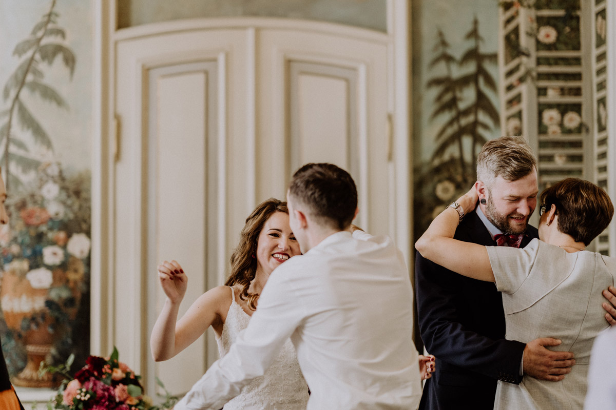 Emotionale Gratulation nach der Trauung: Brautpaar umarmt überglücklich seine Gäste im Standesamt Berlin Mitte