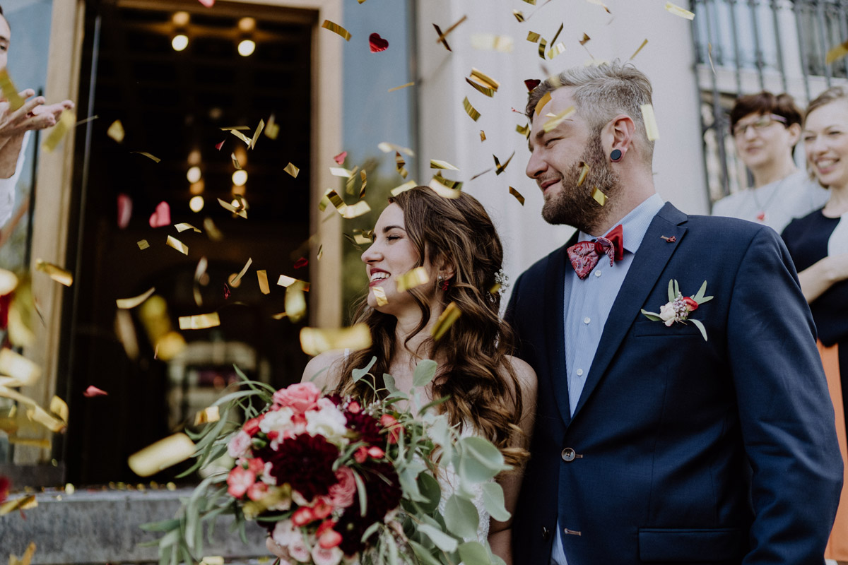 Pure Freude nach der Heirat: Strahlendes Brautpaar wird beim Auszug aus dem Standesamt in Berlin von Konfetti umhüllt