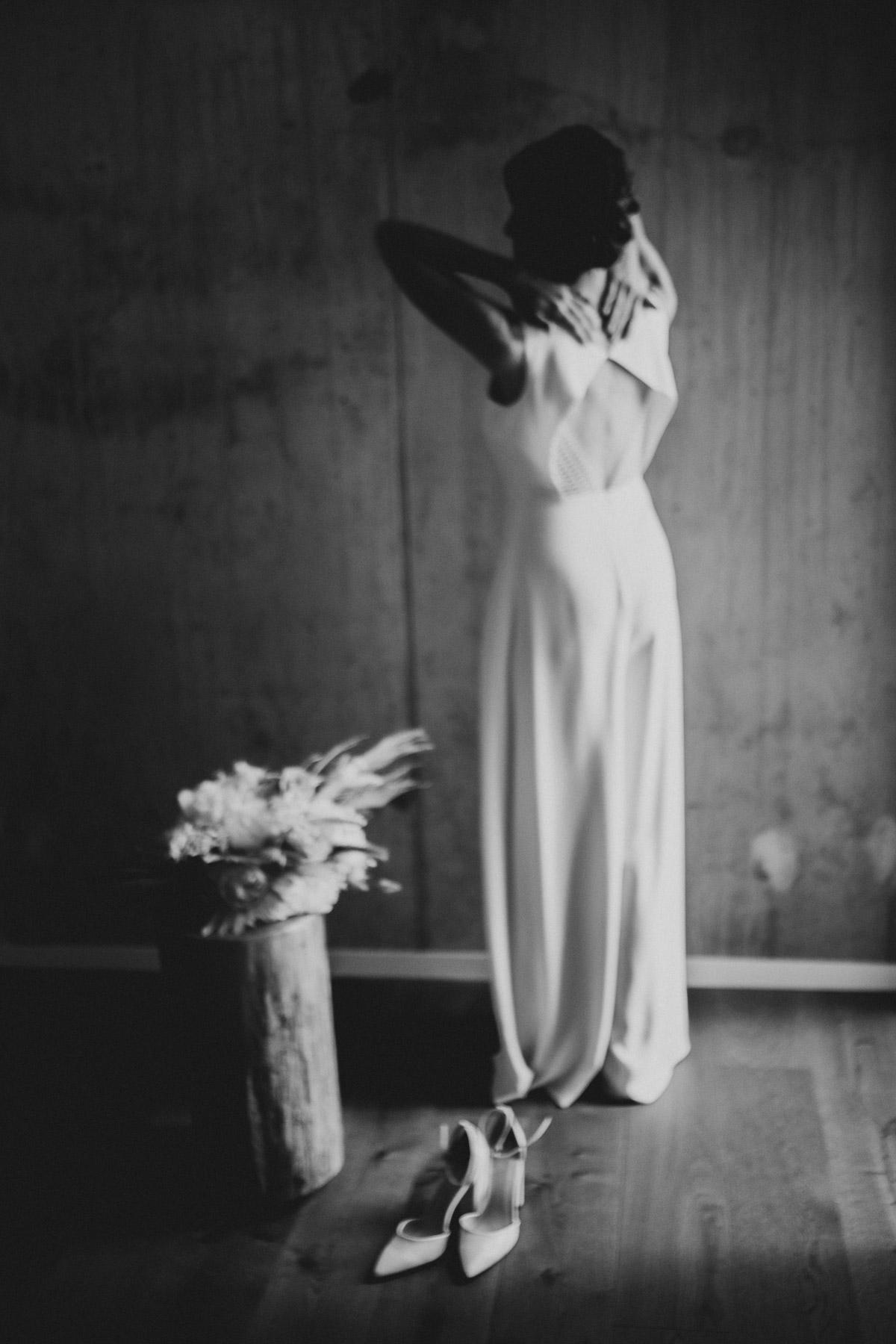Atmosphärisches Getting Ready im KPM Hotel Berlin: Braut zieht ihr modernes Brautkleid - einen Jumpsuit - an, Schwarz-Weiß Aufnahme
