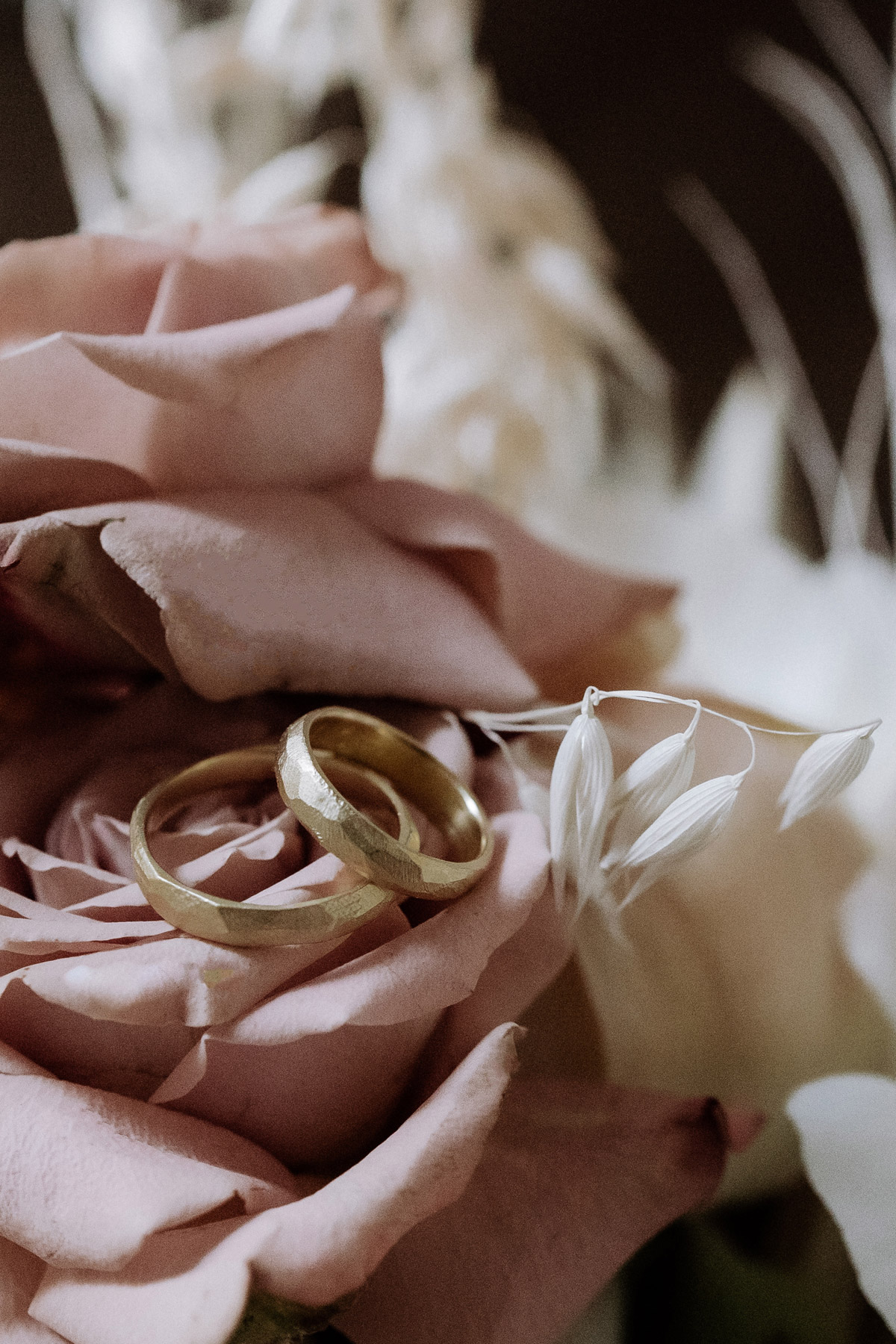 Goldene Eheringe liegen auf dem Brautstrauß