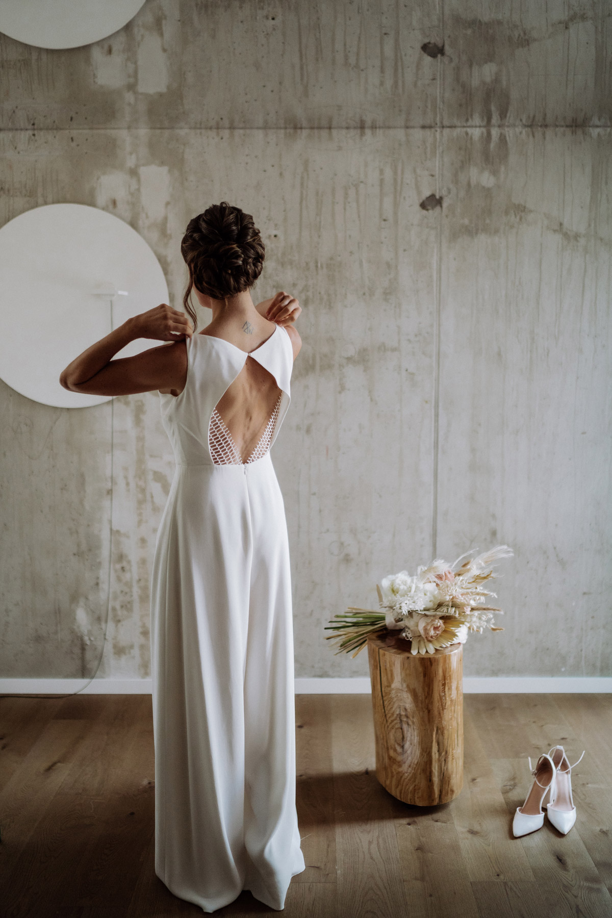Braut von hinten zieht Jumpsuit von Kisui Berlin an