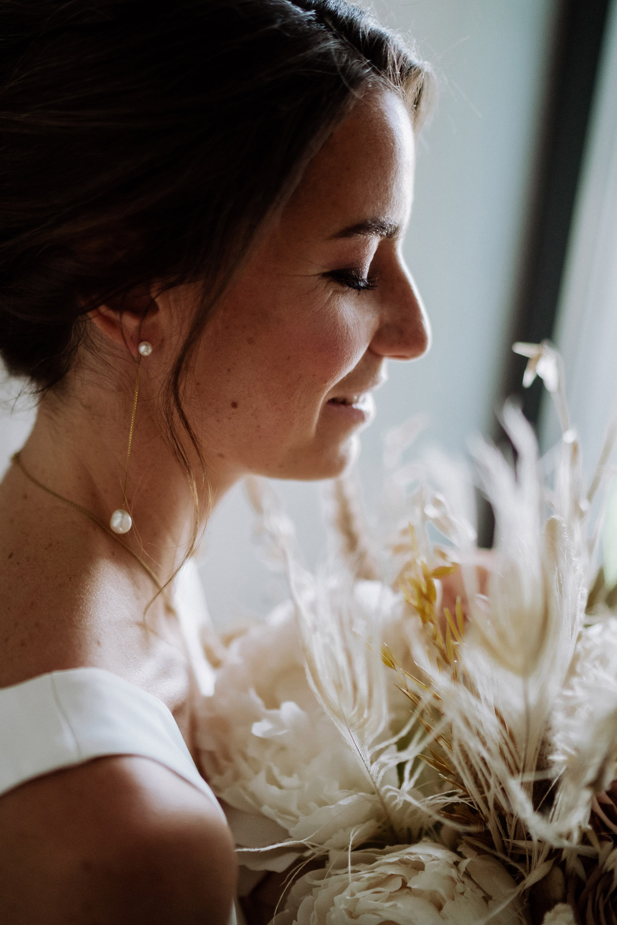 Braut riecht glücklich am Brautstrauß