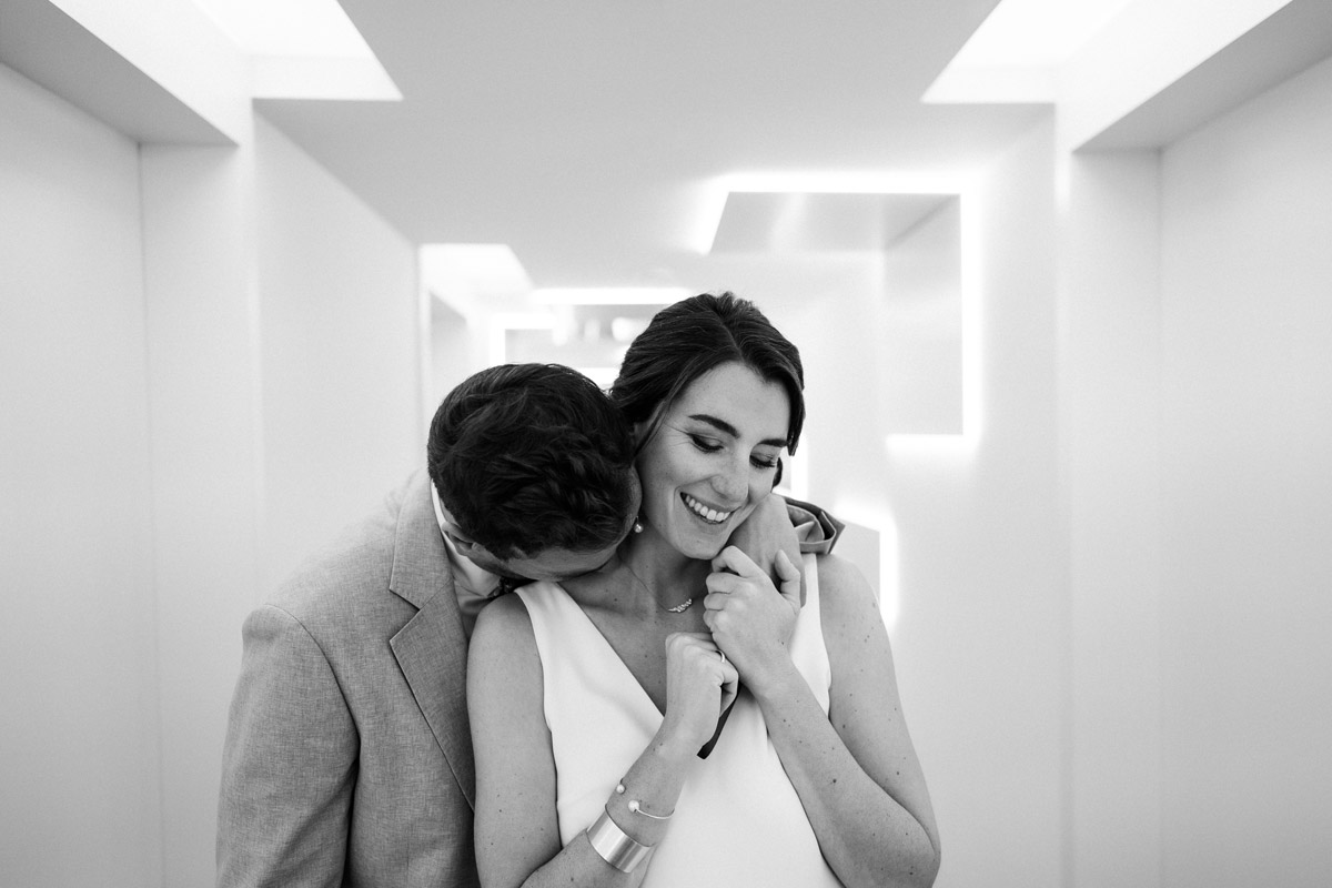 Hochzeitsfoto in Schwarz-Weiß: Bräutigam küsst Braut auf den Hals