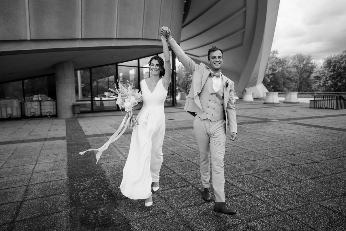 Brautpaar läuft feiernd auf die Kamera zu