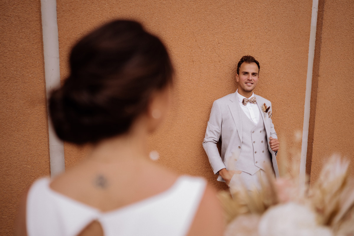 Kreatives Bräutigamportrait: Die Braut ist im Vordergrund unscharf zu sehen