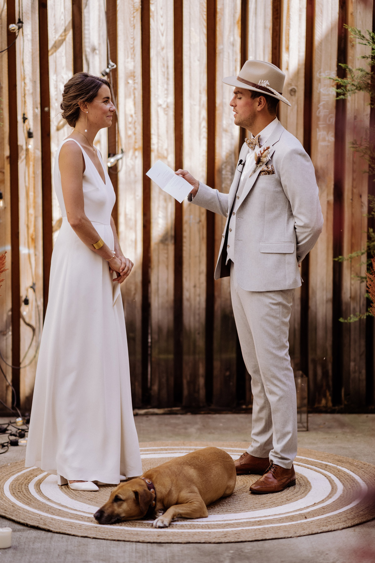 Bräutigam in hellem Anzug liest sein Eheversprechen vor