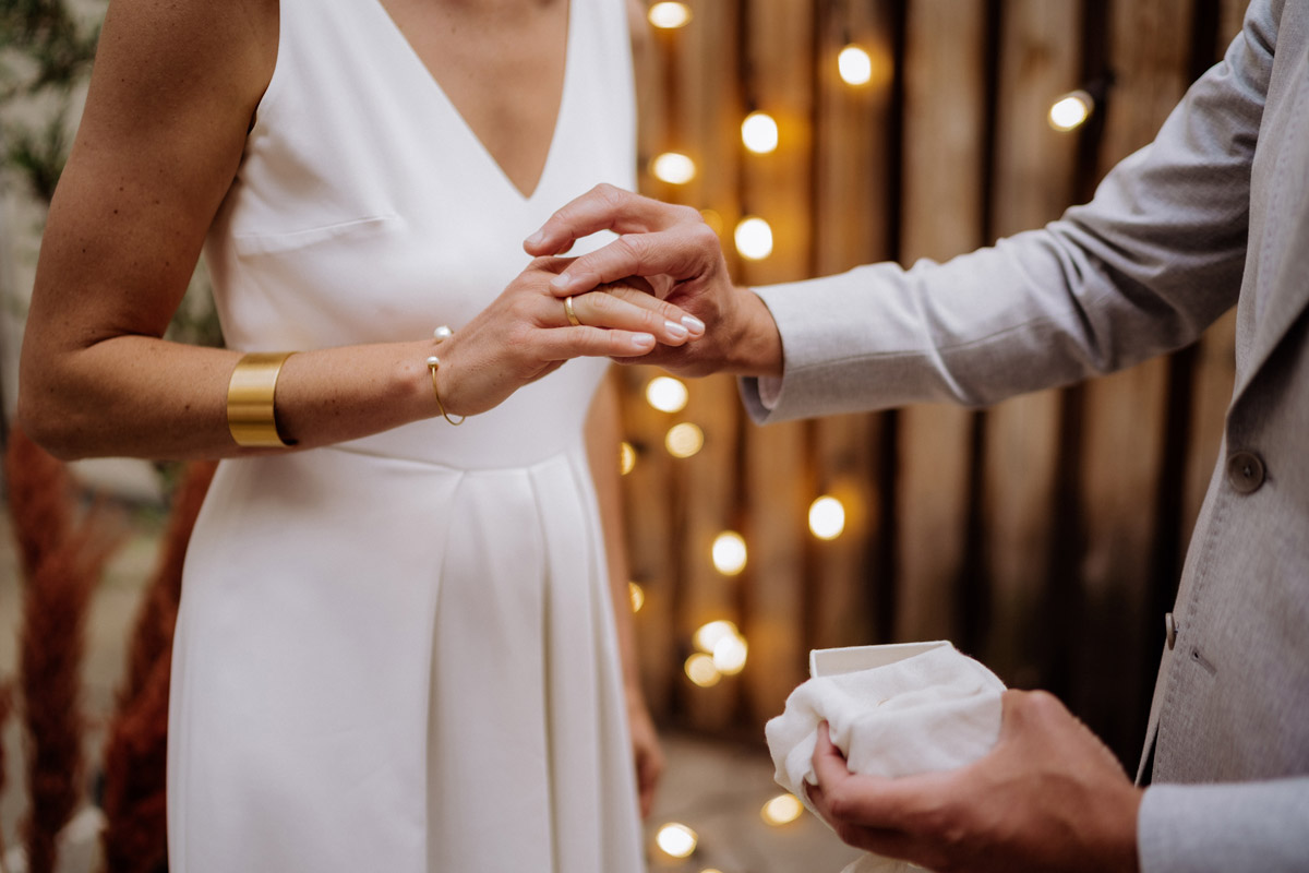 Detailaufnahme Hand der Braut: Ehering wird vom Bräutigam aufgesteckt