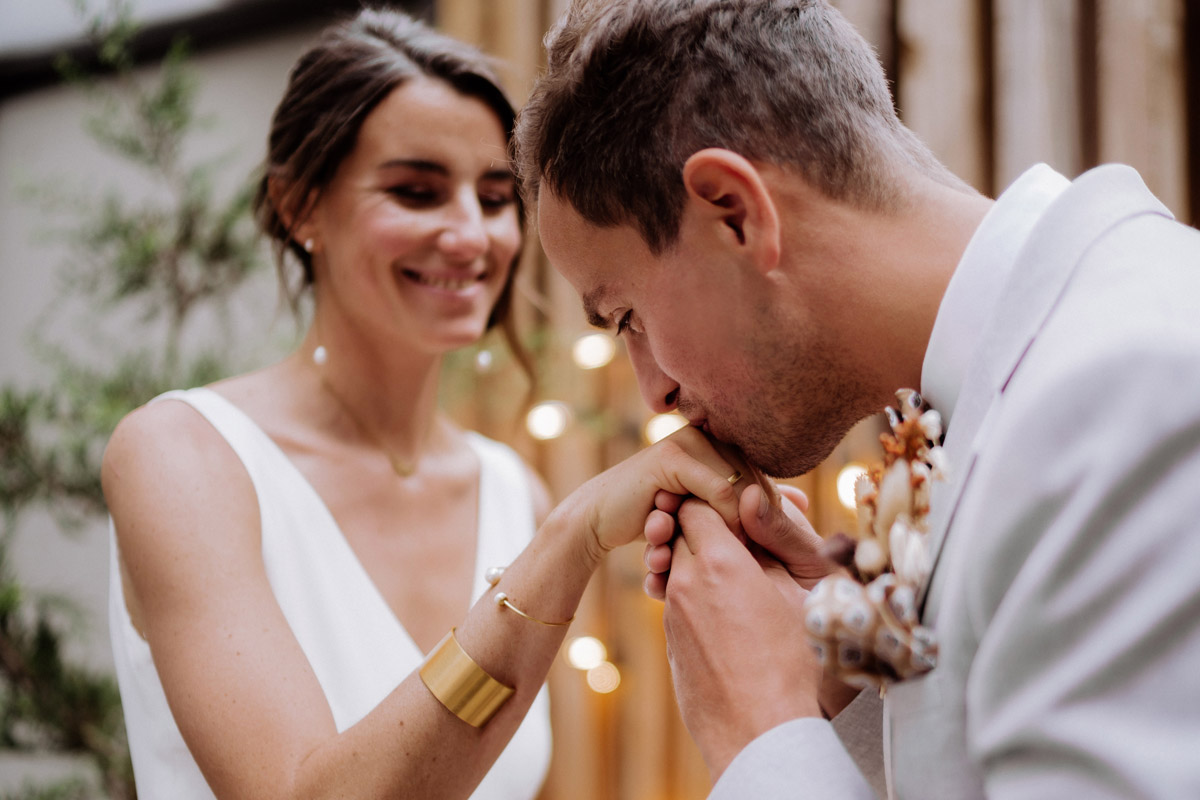 Zärtlicher Hochzeitsmoment: Bräutigam küsst die Hand der Braut
