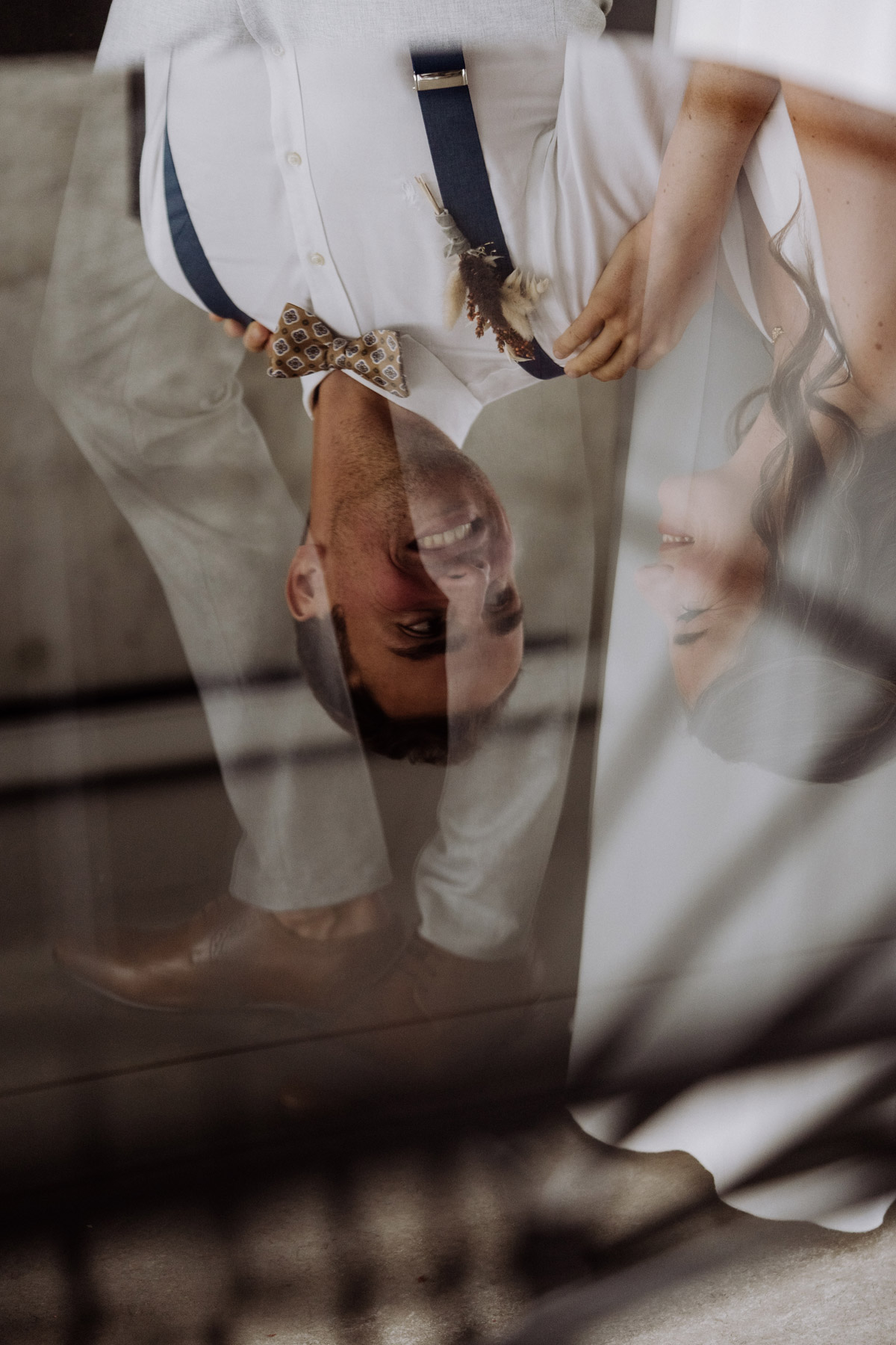 Kreatives Hochzeitsfoto mit Spiegelung des Paares im Glastisch