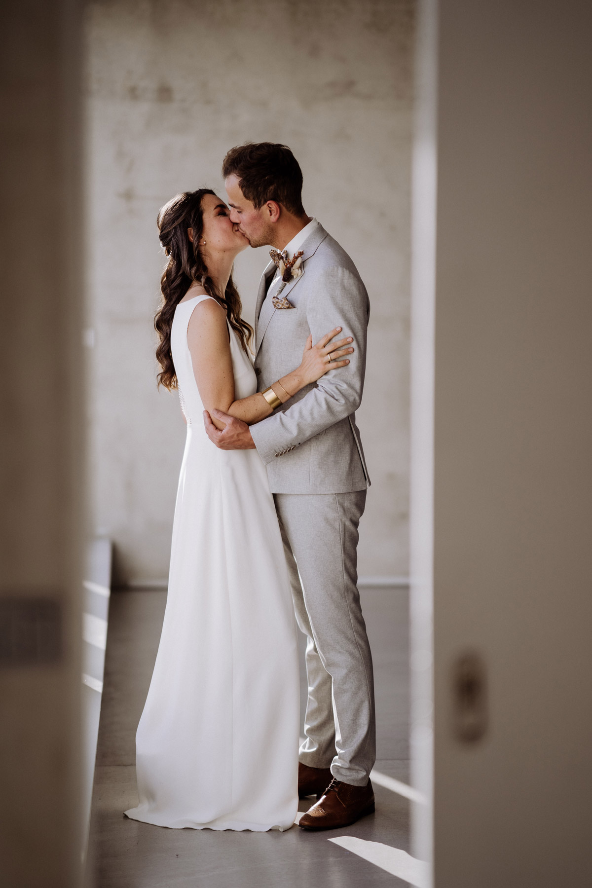 Paar küsst sich im schönen Hochzeitslicht der Berliner Location