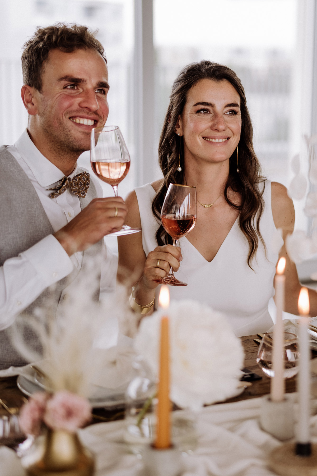 Brautpaar stößt am Hochzeitstisch an