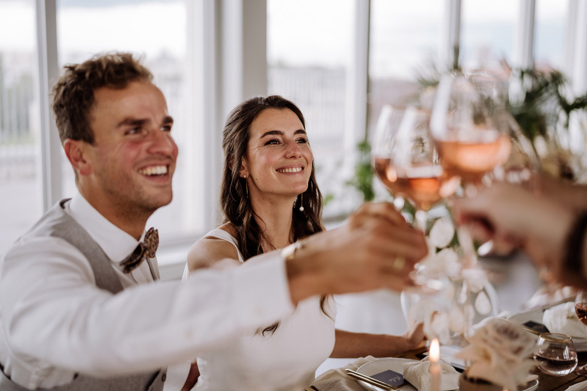 Hochzeitspaar stößt fröhlich mit den Gästen an