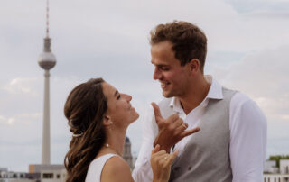 Lockeres Brautpaar beim Rooftop Elopement in Berlin mit Fernsehturm im Hintergrund: Urbane Hochzeitsfotos über den Dächern der Stadt