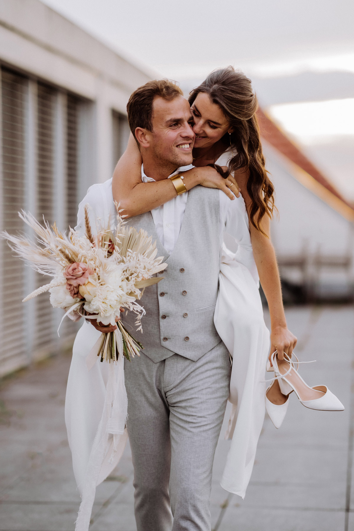 Bräutigam trägt Braut huckepack