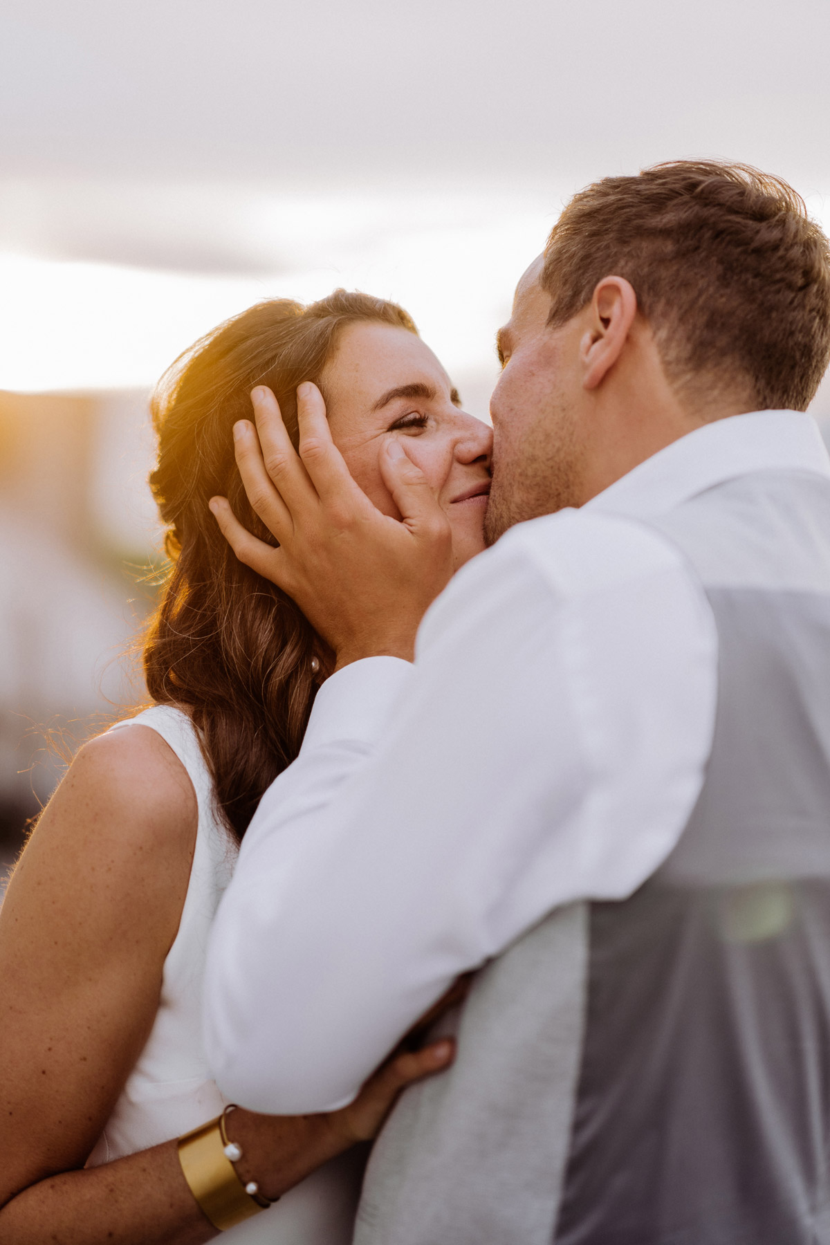 Romantische Stimmung beim Rooftop Elopement Berlin: Brautpaar küsst sich im Sonnenuntergangslicht