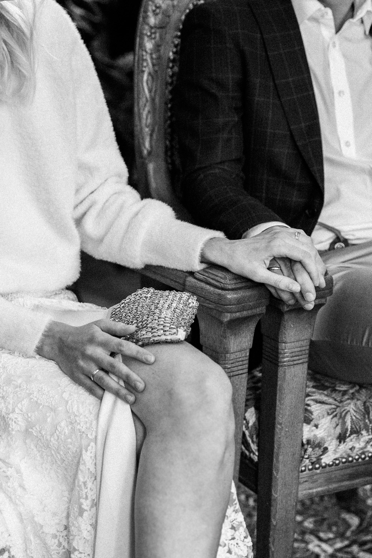 Detailaufnahme der Hände des Brautpaares während der intimen Zeremonie im Standesamt