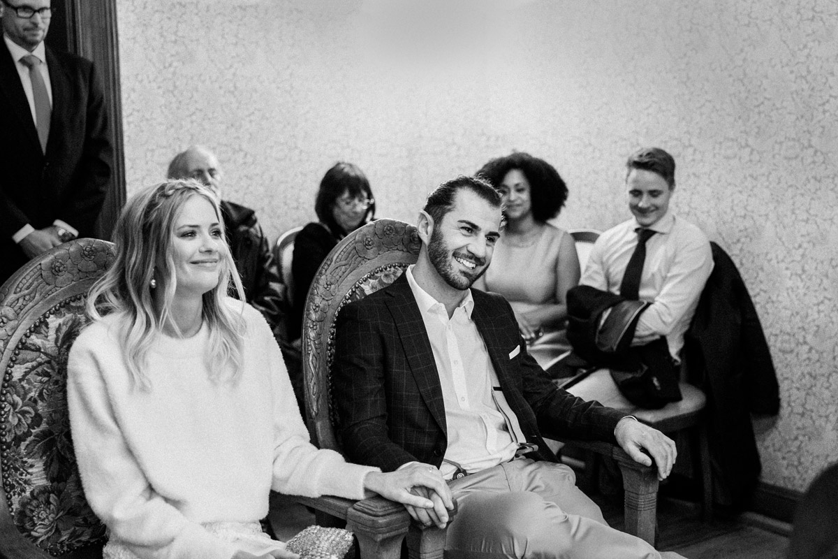 Standesamt Charlottenburg-Wilmersdorf Trauraum: Strahlendes Brautpaar lächelt sich während der standesamtlichen Eheschließung an