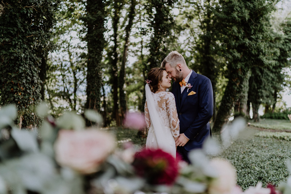 Romantisches Brautpaar-Portrait im grünen Gutspark von Schloss Golm
