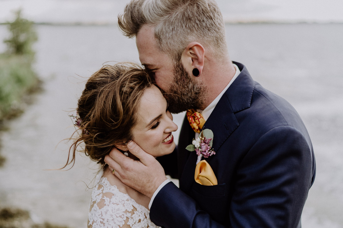 Golm Hochzeit: Inniger, verträumter Moment zwischen Braut und Bräutigam am Wasser beim romantischen Brautpaarfotoshooting