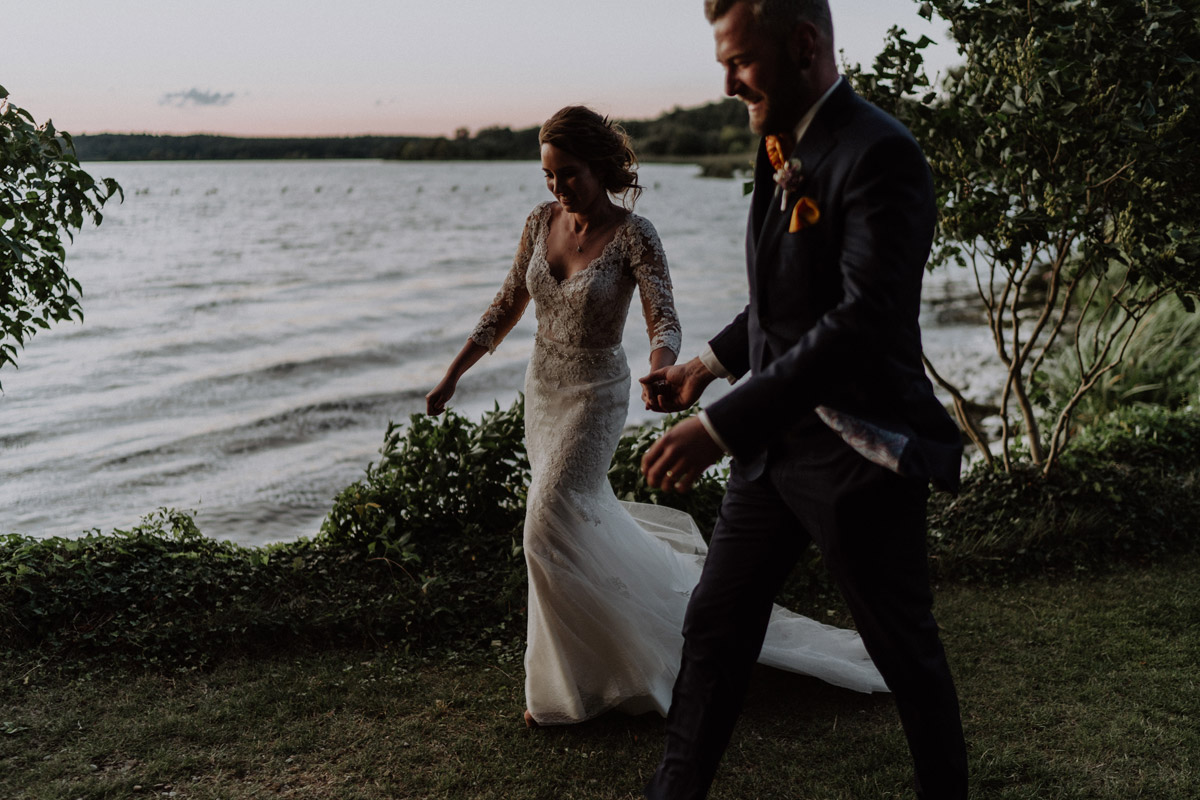 Natürliches und bewegtes Brautpaarfoto beim Laufen durch die Naturkulisse am Zernsee