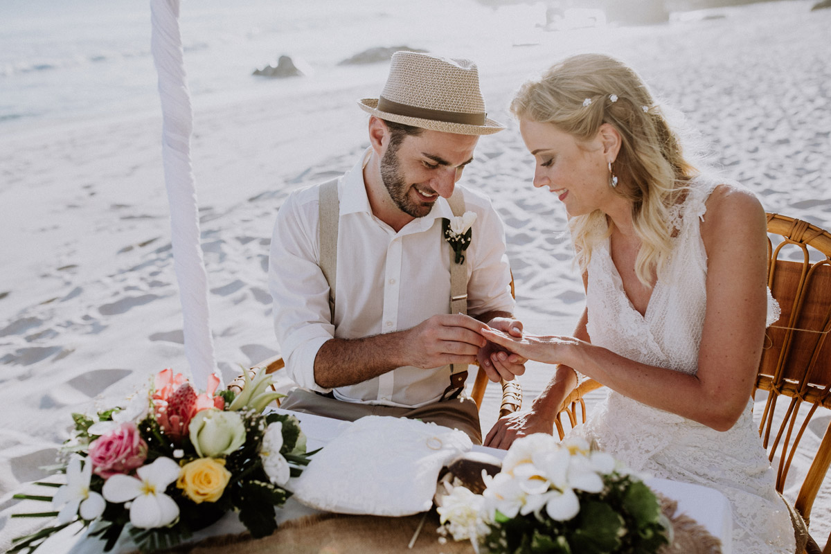 Elopement auf den Seychellen: Nach der formellen Eheschließung in der Villa Kogge steckt der Bräutigam seiner Braut bei der freien Strandhochzeit den Ring an