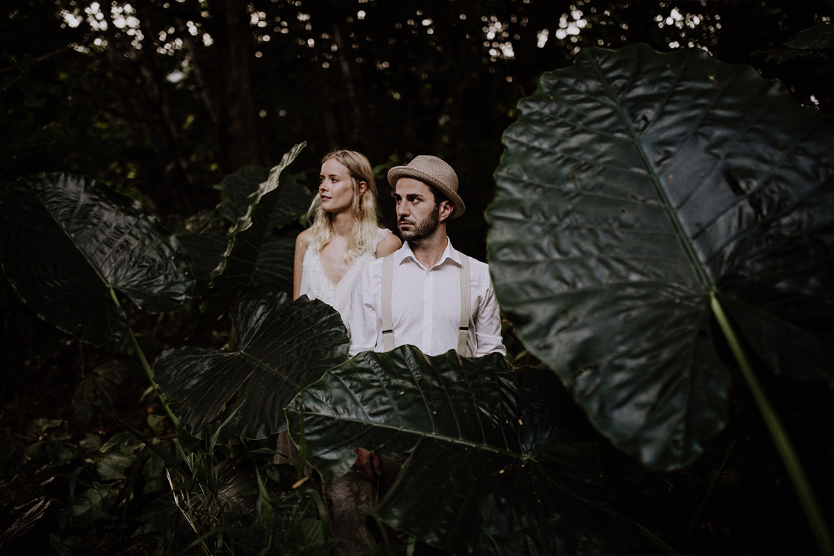 Hochzeitsfotos im Ausland: Romantisches Brautpaar-Shooting zwischen riesigen, tropischen Blättern im Dschungel als Kontrast zum urbanen Standesamt in Charlottenburg