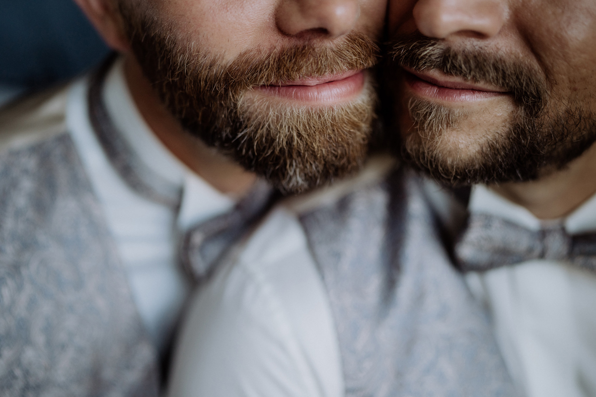 Detailaufnahme Gay Wedding: Glückliches Lächeln der Bräutigame mit Bart beim Getting Ready für Standesamt Potsdam Hochzeit