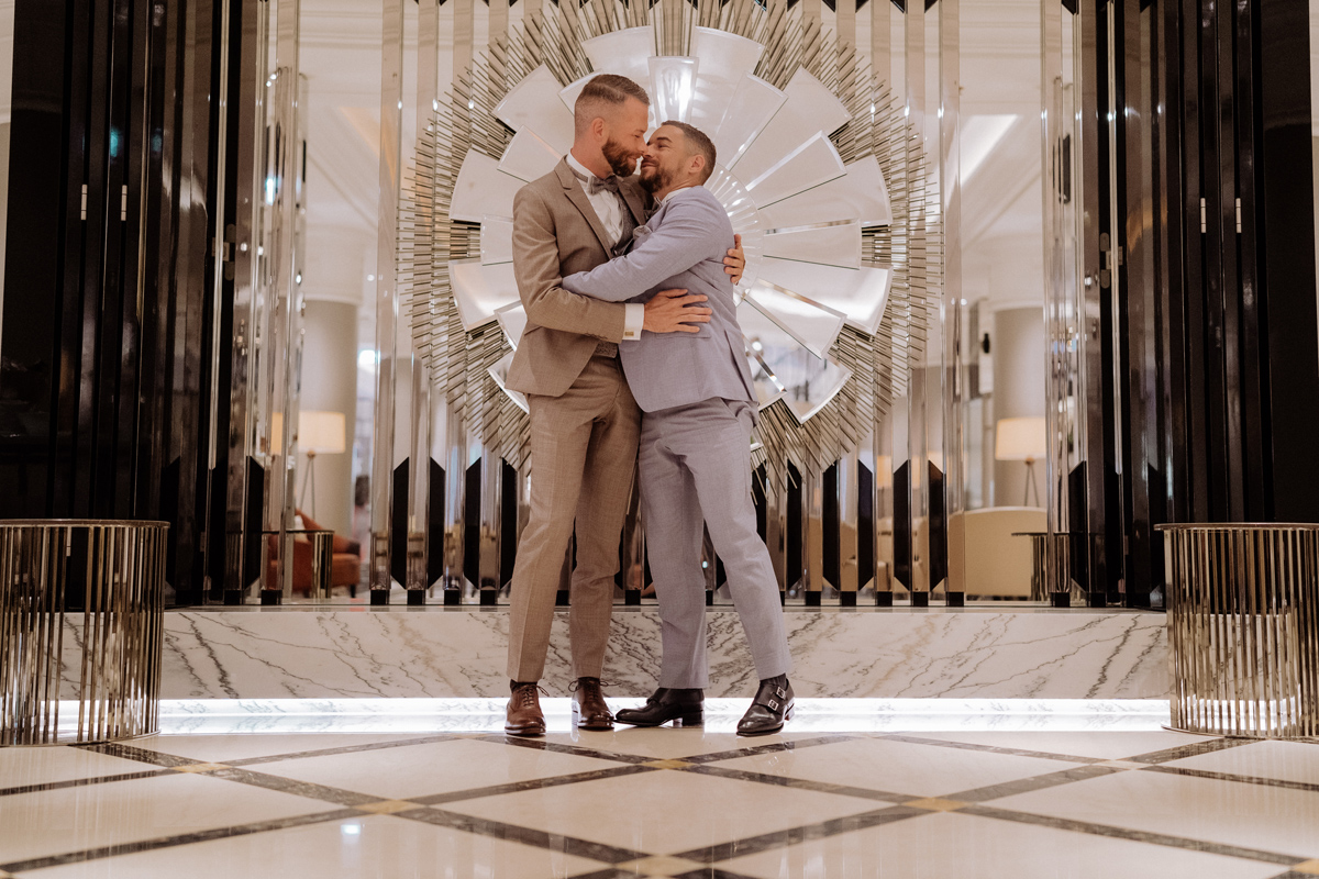 schwule Hochzeit Männer küssen sich beinahe vor Spiegel in Eingangshalle des Ritz-Carlton Berlin