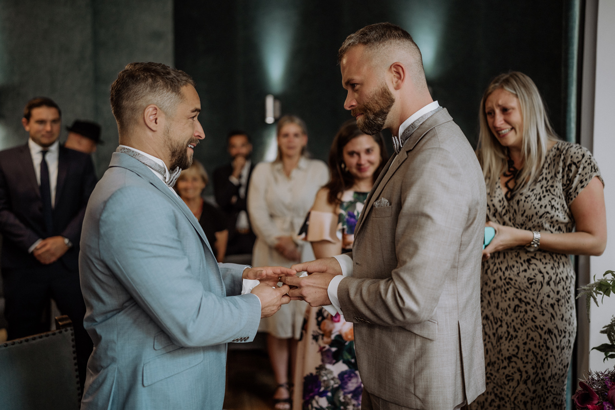 Bräutigame stecken sich Eheringe auf