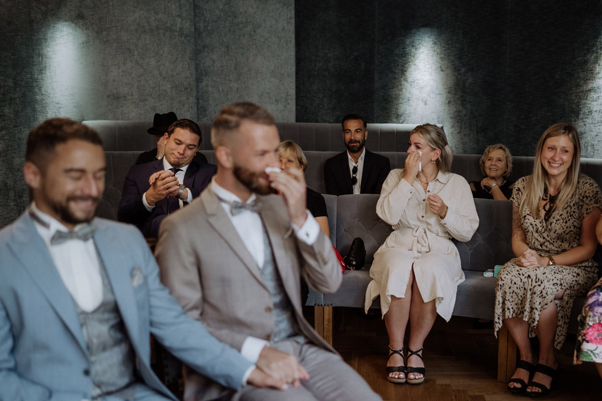 Hochzeitsmoment: Gast wirft ironisch Blick auf die Uhr während viele Gäste weinen
