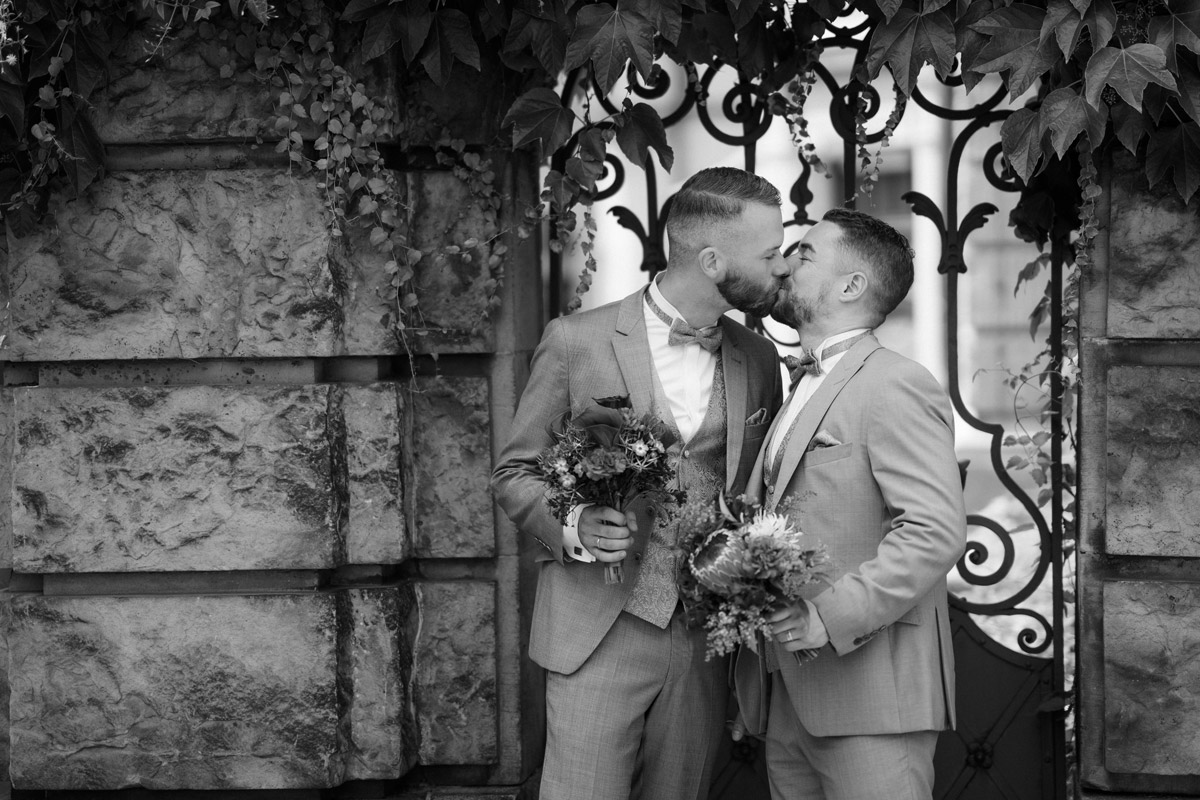 schwules Brautpaar küsst sich in Schwarz Weiß