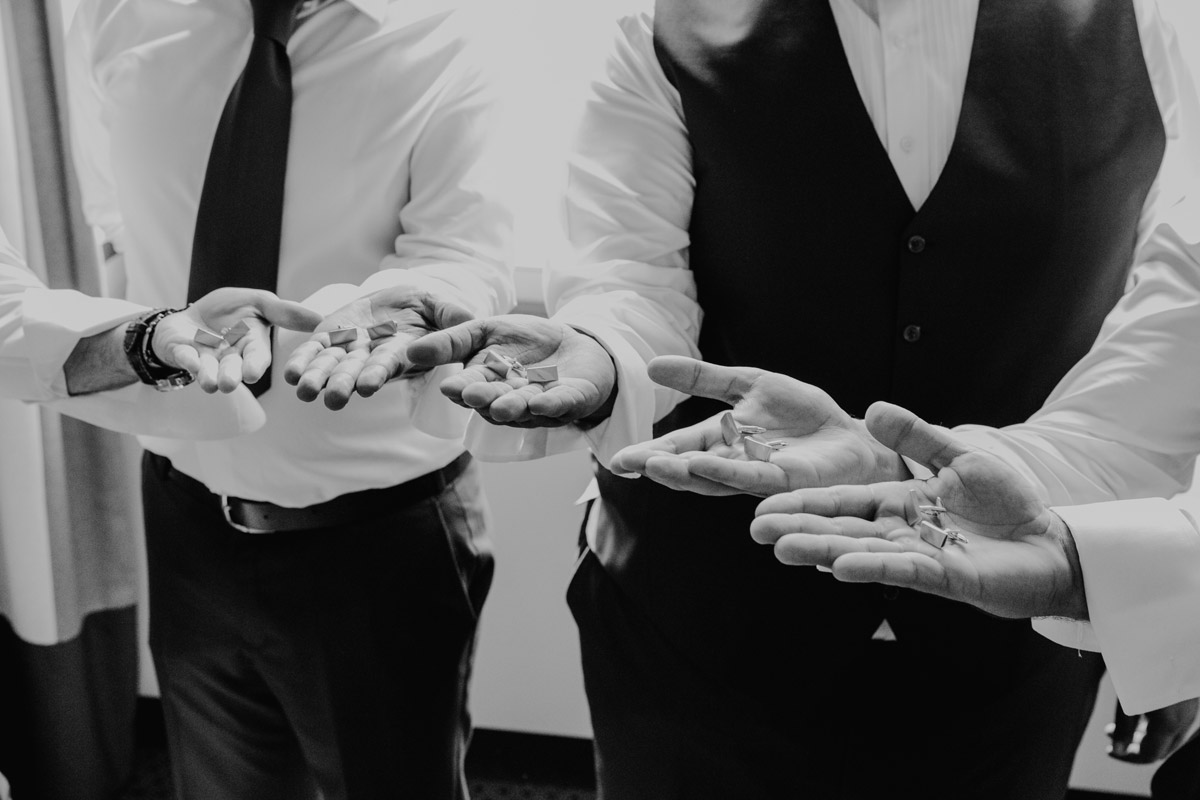 Detailaufnahme Manschettenknöpfe liegen auf den Händen der Männer