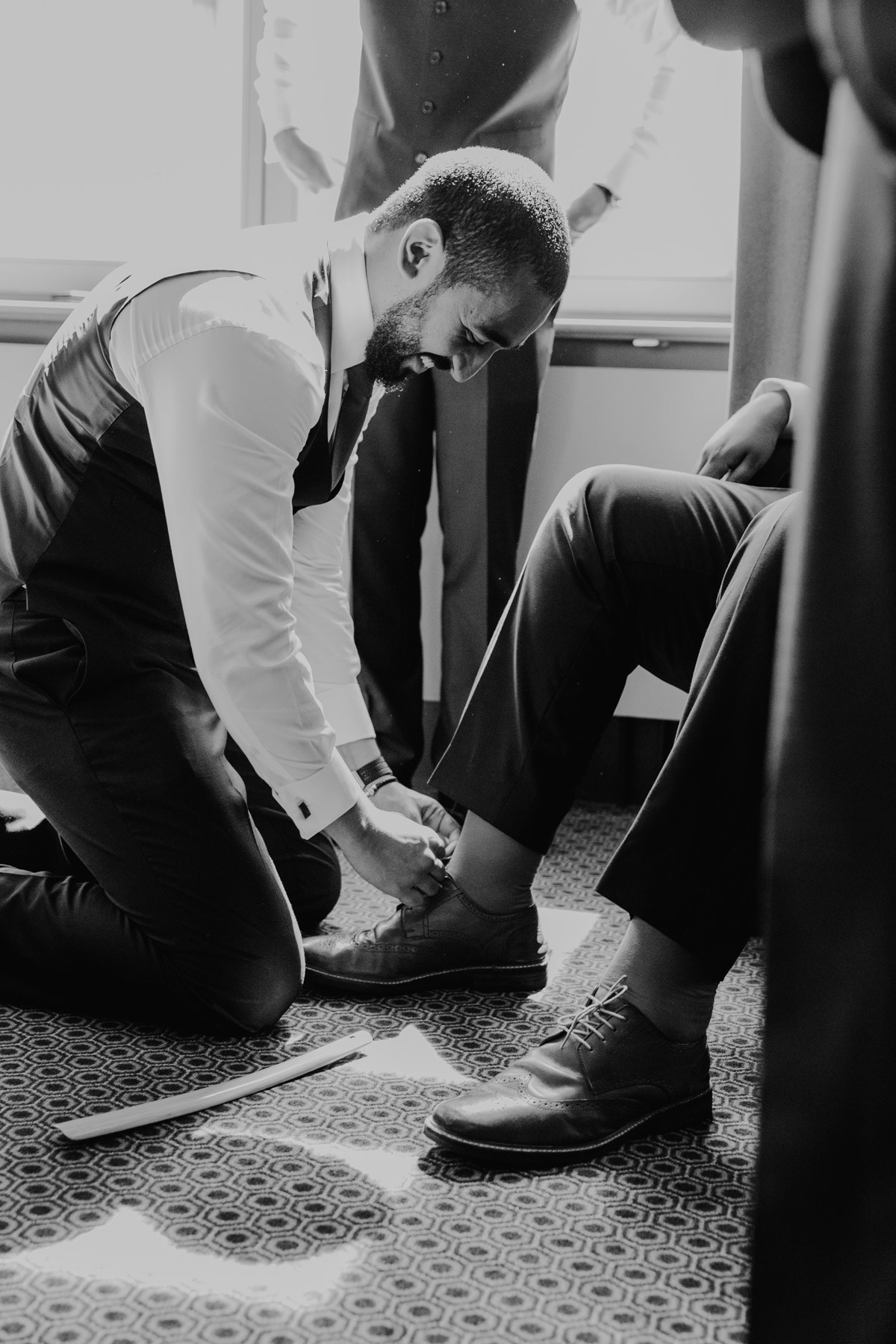 Trauzeuge zieht Bräutigam Schuhe an