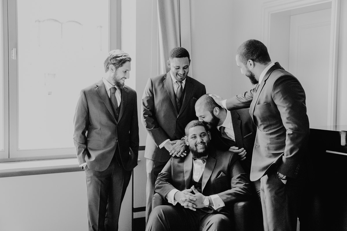 Emotionale Momente mit den Trauzeugen: Bräutigam wird von seinen Freunden umarmt und beglückwünscht – Authentische Hochzeitsfotos