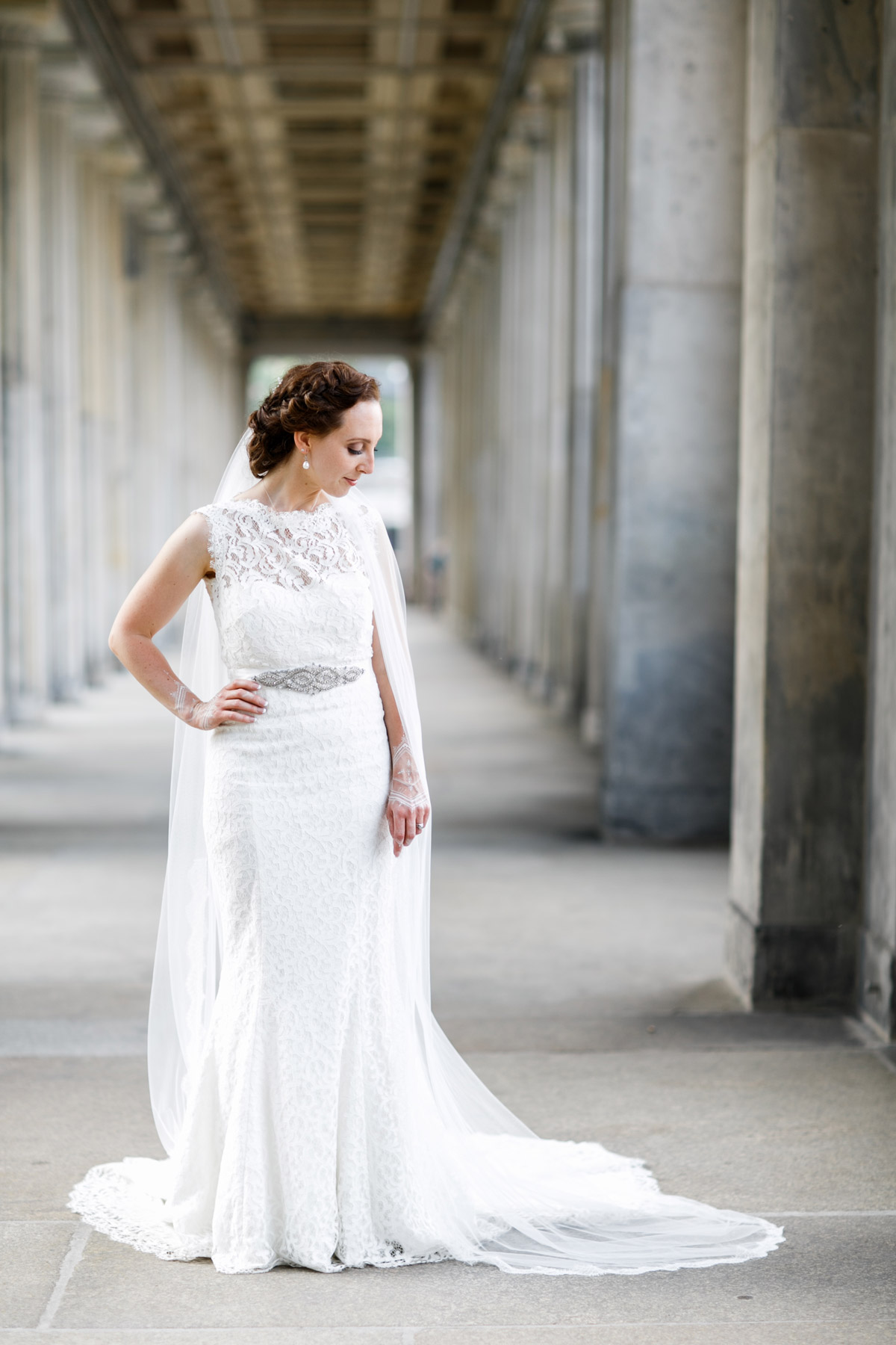 Braut im Meerjungfrauen-Stil Hochzeitskleid mit langem Schleier: Ganzkörperportrait in den berühmten Kolonnaden auf der Museumsinsel am Wasser