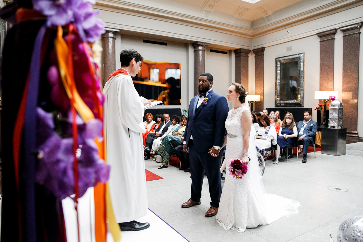 Freie Trauung im Hotel de Rome: Emotionaler Moment am Altar, internationales Brautpaar steht vor dem Trauredner im Ballsaal