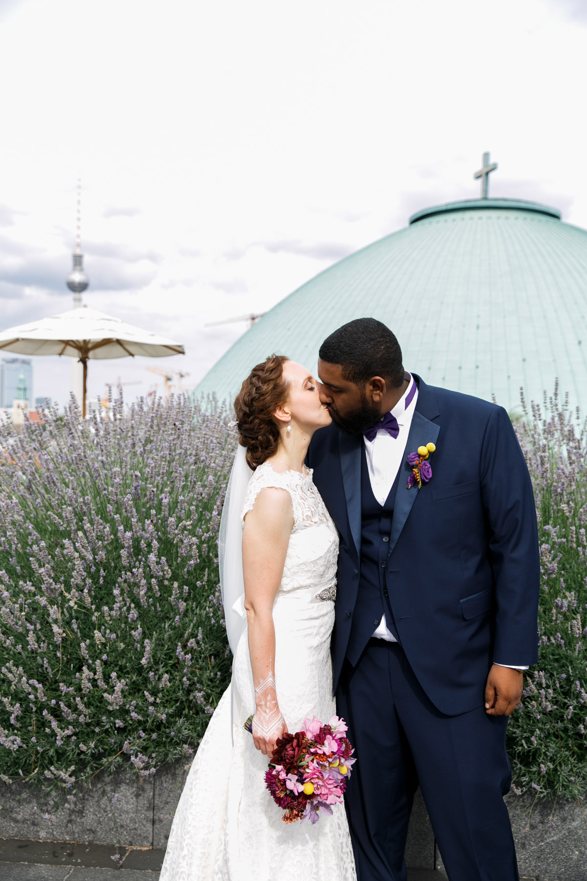 Brautpaar küsst sich vor Lavendelbeet auf der Dachterrasse des Hotel de Rome