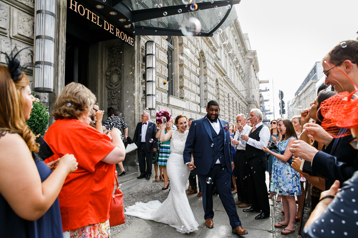 Hotel de Rome Berlin Hochzeit: Traumhafter Auszug des Brautpaares aus dem Hotel durch ein Spalier aus Seifenblasen am Bebelplatz