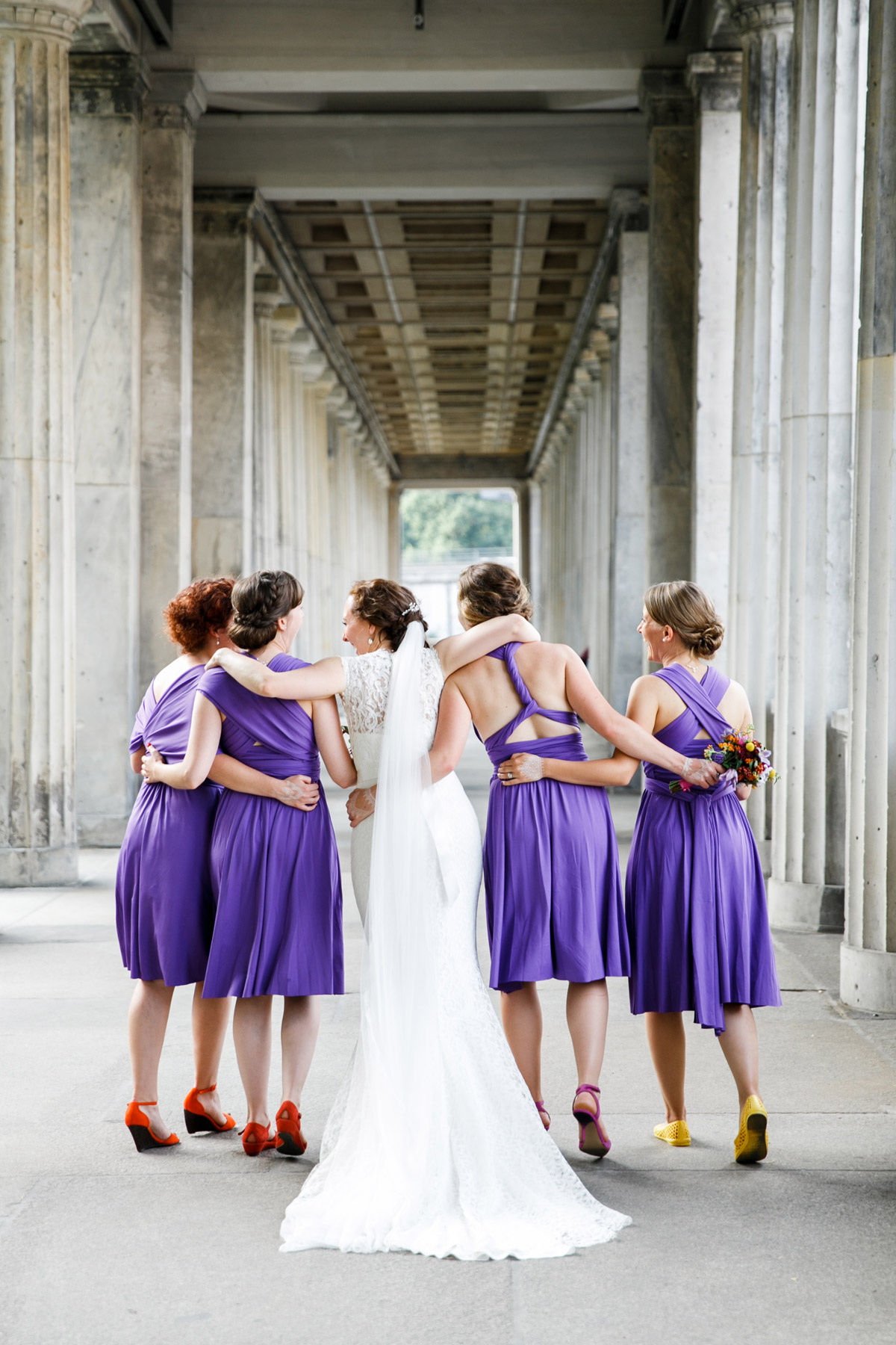 Elegantes Gruppenfoto der Braut und Brautjungfern von hinten in den Kolonnaden auf der Museumsinsel