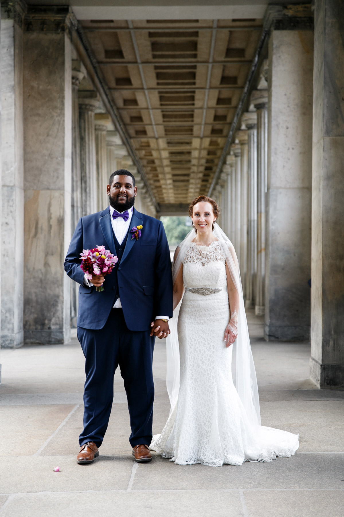 Ganzkörperaufnahme: internationales Hochzeitspaar hält sich an den Händen