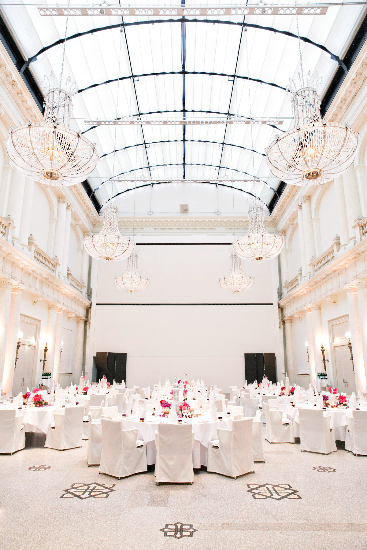 Prunkvoller Ballsaal im Hotel de Rome Berlin: Festlich eingedeckte Tische für das Hochzeitsdinner unter der gläsernen Decke