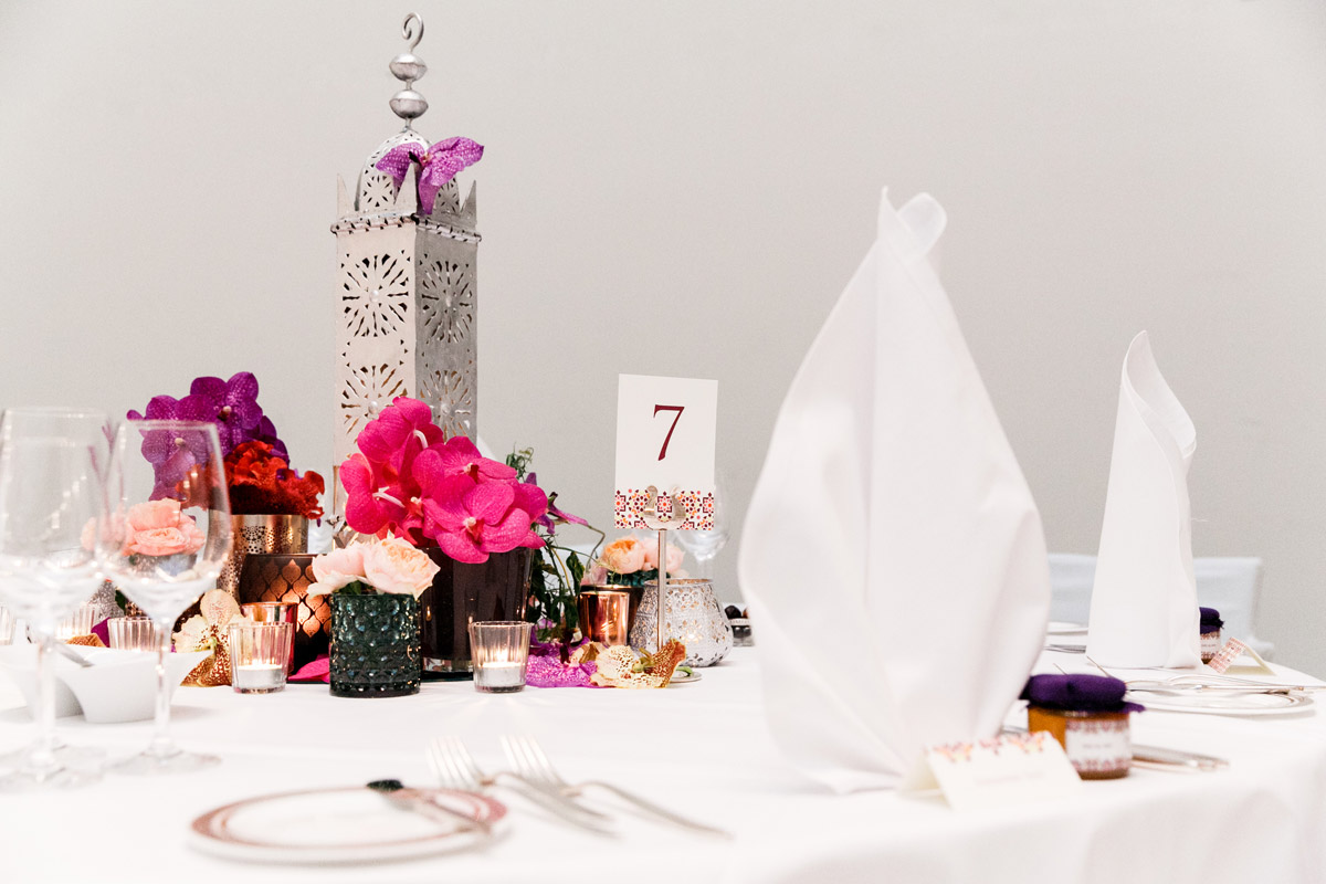Orientalische Tischdeko im Hotel de Rome: Hohe silberne Laterne, kombiniert mit exotischen Blumengestecken und Tischnummer 7