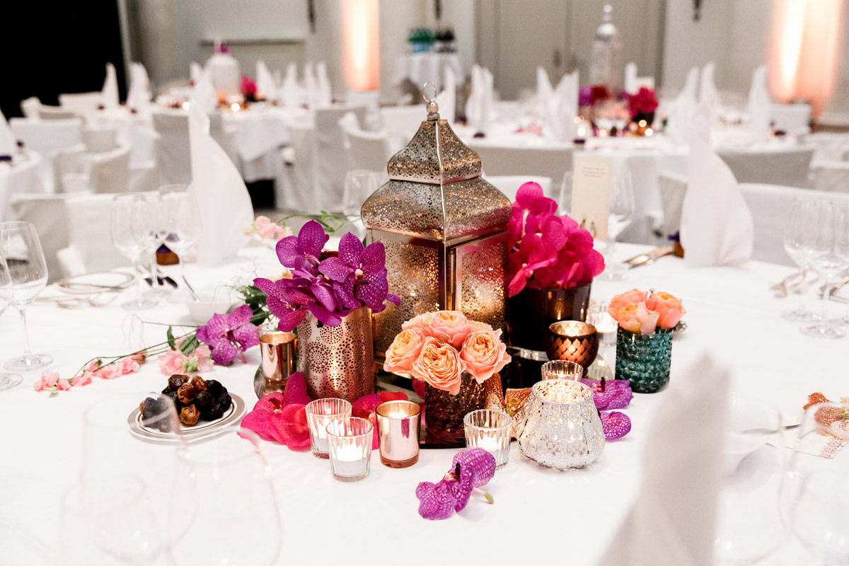 Orientalische Hochzeitsdeko Berlin: Silberne Laterne als Centerpiece umgeben von Datteln, Orchideen und vielen Kerzen für eine warme Atmosphäre