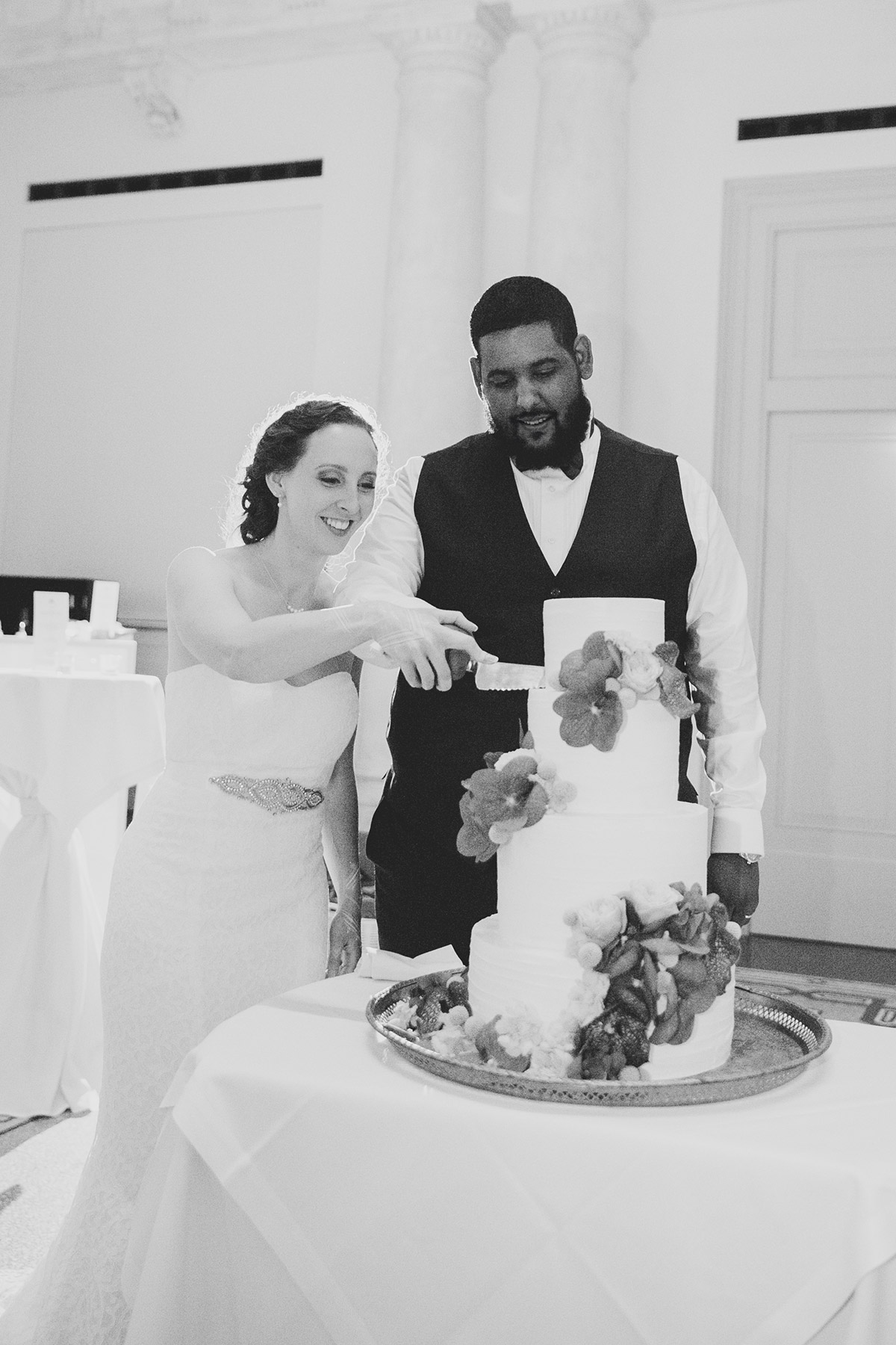 Das Brautpaar beim gemeinsamen Anschneiden der klassischen Hochzeitstorte – Traditioneller Moment der Hochzeitsfeier in Berlin Mitte