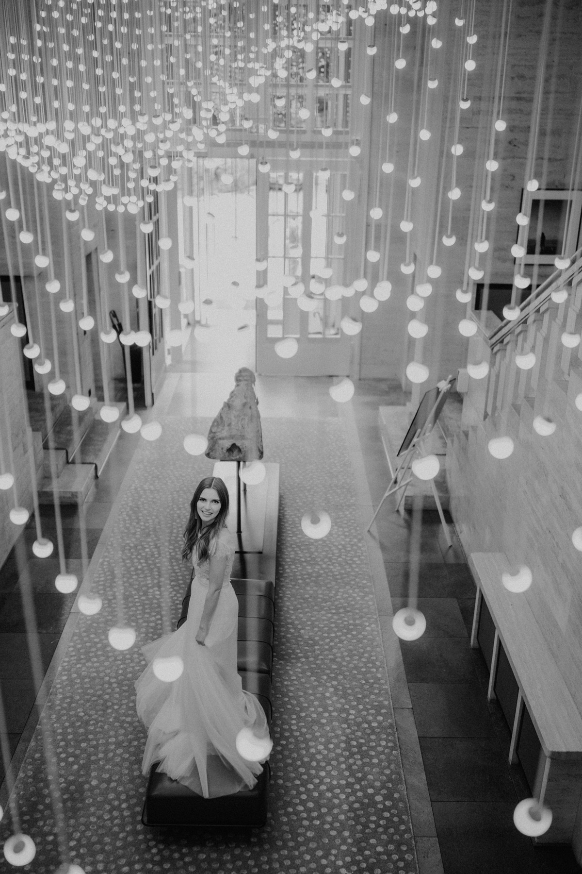 Vogelperspektive auf die Braut im Foyer des SO/ Berlin Das Stue: Elegantes Schwarz-Weiß Foto