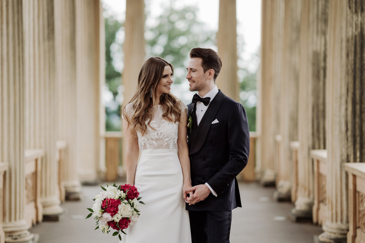 Hochzeitsfotograf Potsdam: Elegantes Brautpaar-Portrait zwischen den Säulen des Belvedere Pfingstberg nach der Trauung