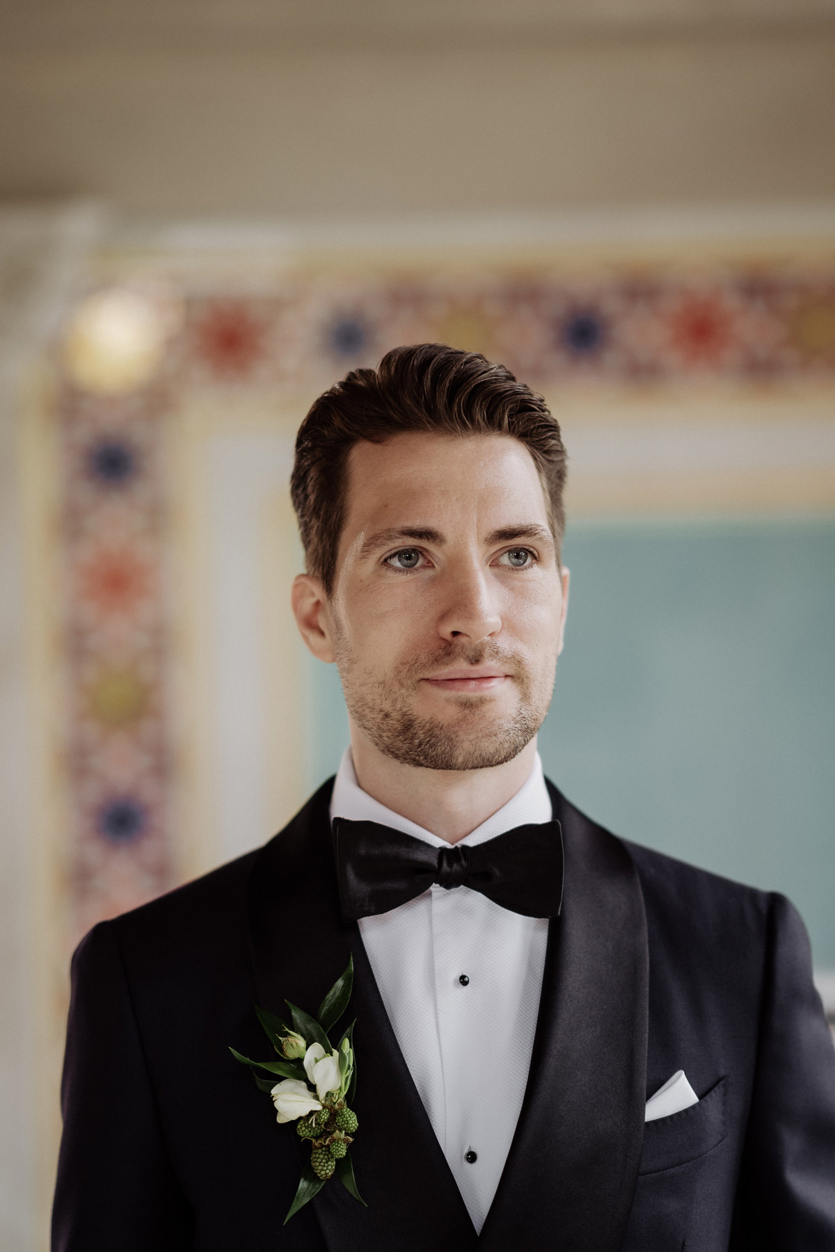 Portrait des wartenden Bräutigams vor der historischen Fliesenwand im Maurischen Kabinett