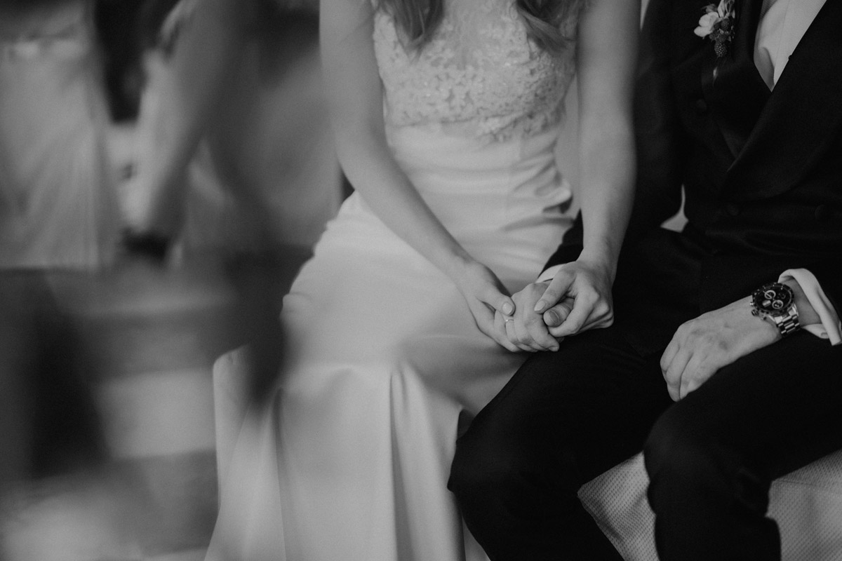 Detailaufnahme: Hände des Hochzeitspaares berühren sich zärtlich – Schwarz-Weiß Fotografie