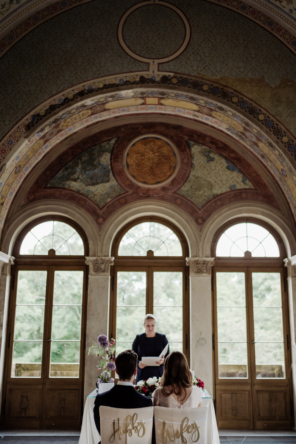 Lichtstimmung im Ostturm des Belvedere: Brautpaar sitzt vor den großen Rundbogenfenstern